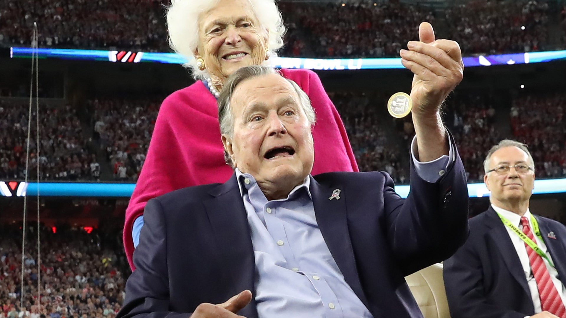 Former U.S. President George H.W. Bush participates in the coin toss ahead of the start of Super Bowl LI between the New England Patriots and the Atlanta Falcons as former first lady Barbara Bush looks on in Houston , Texas