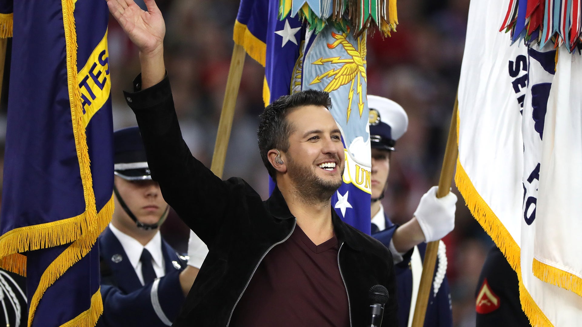 Country Singer Luke Bryan waves before performing the U.S. National Anthem prior to the the start of Super Bowl.