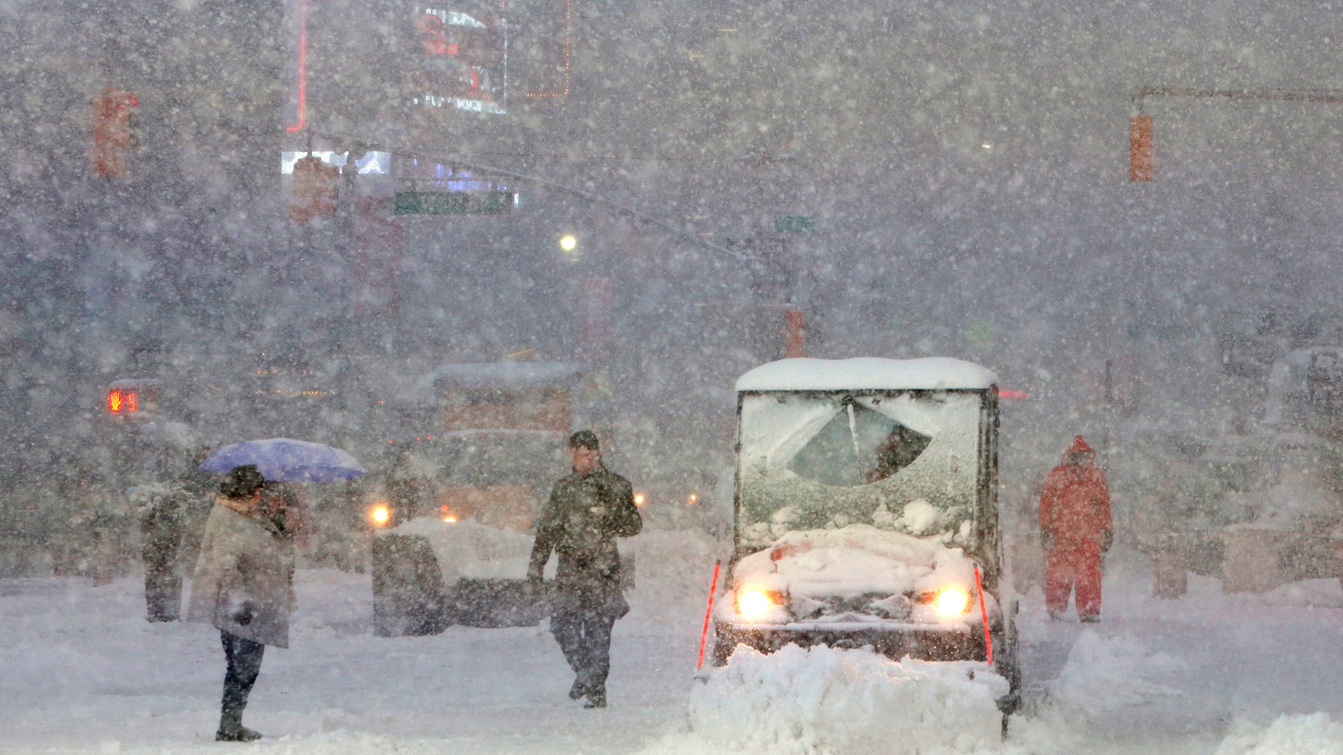 A snowplow drives through Times Square as snow falls in New York.