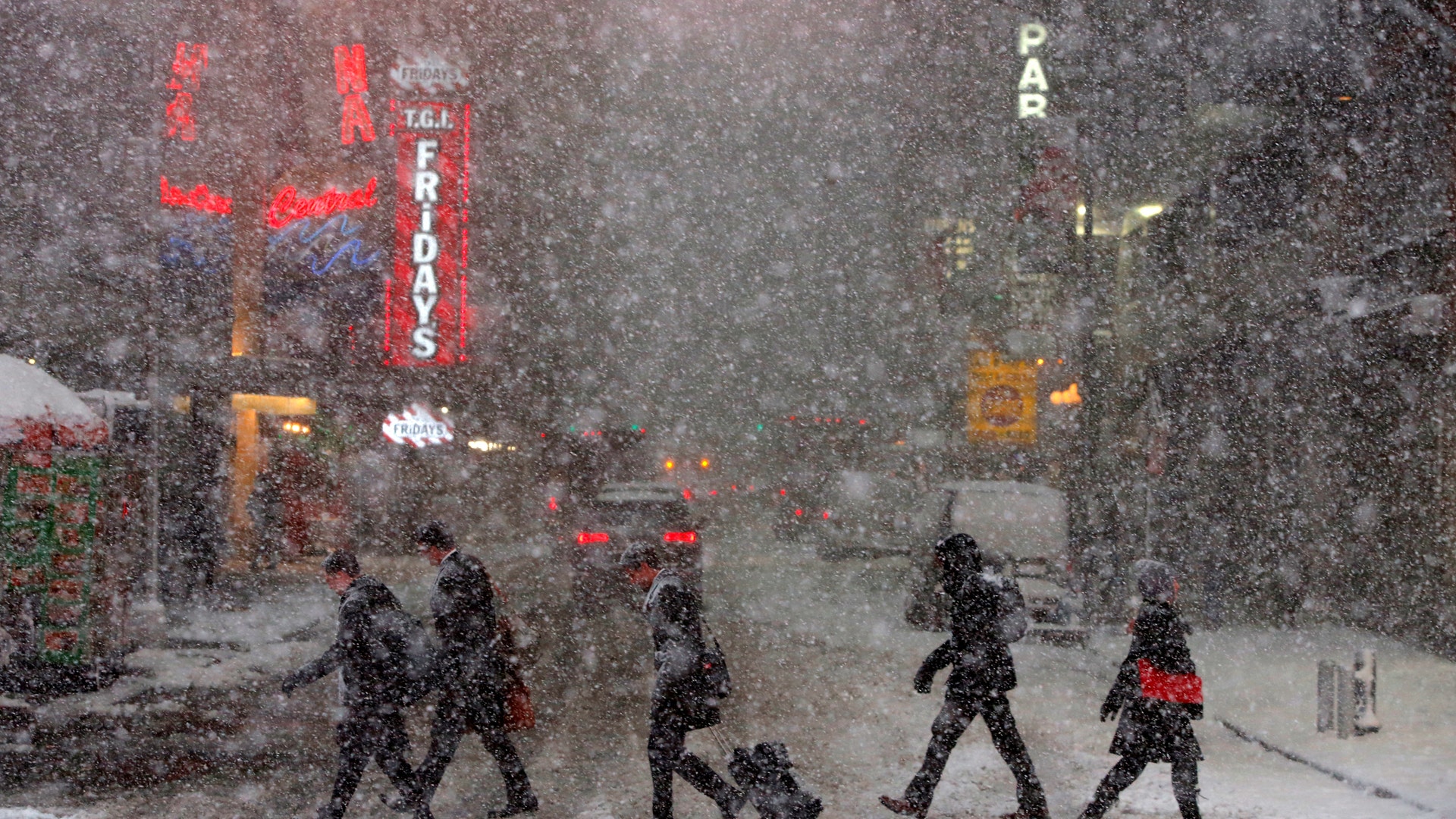 Pedestrians walk in Times Square as snow falls in New York.