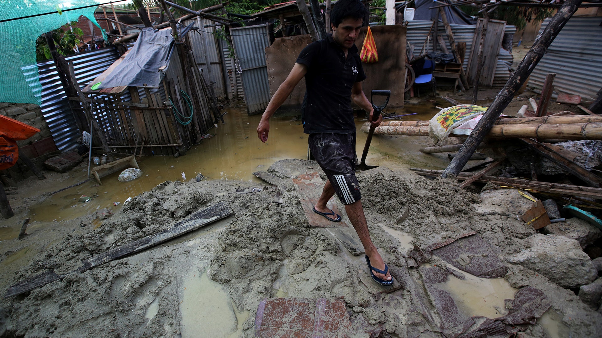 A man walks at his flooded home damaged after heavy rain in Castilla district of  Piura.