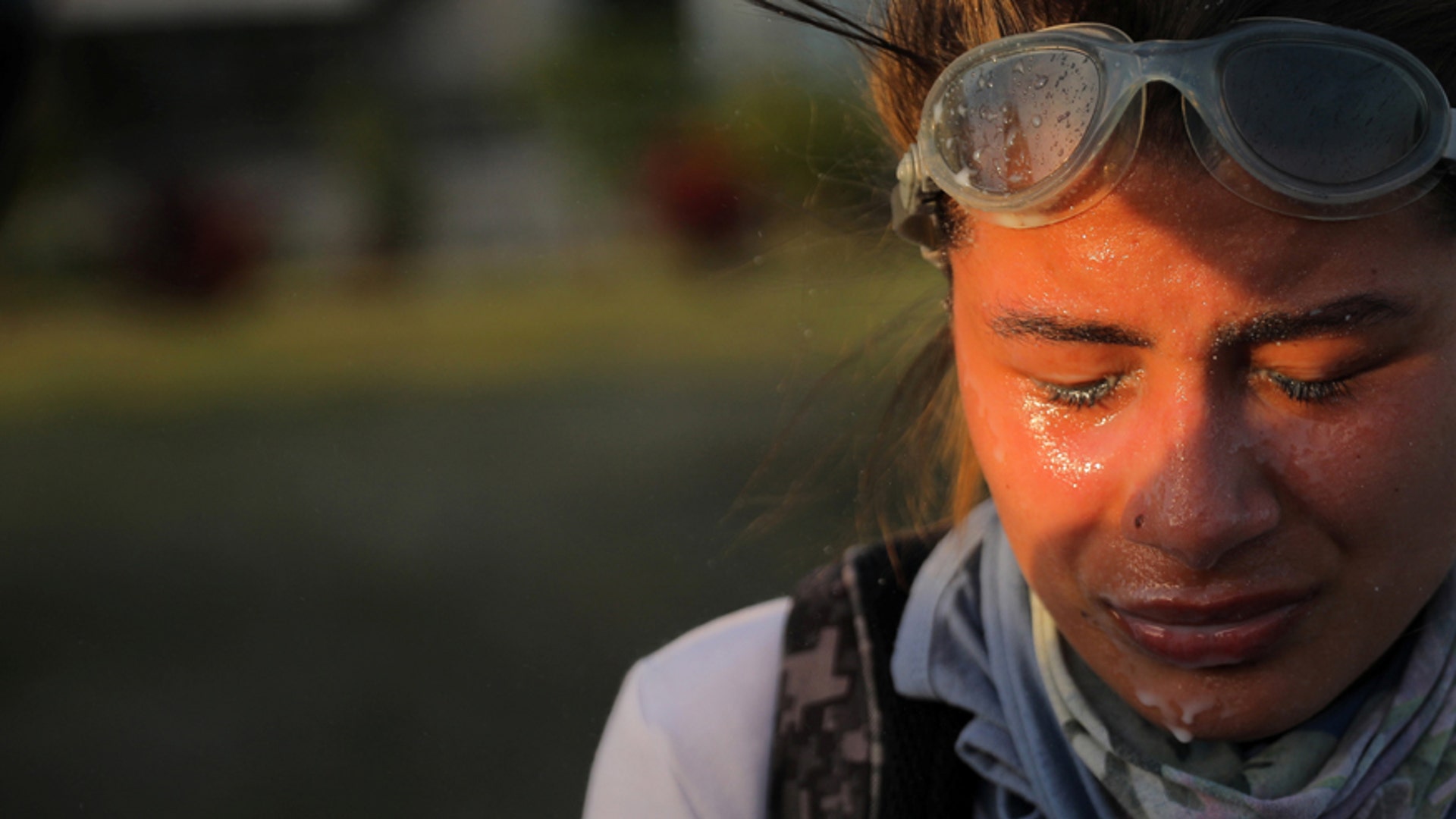 A protester reacts after being treated for tear gas exposure during clashes with riot security forces 