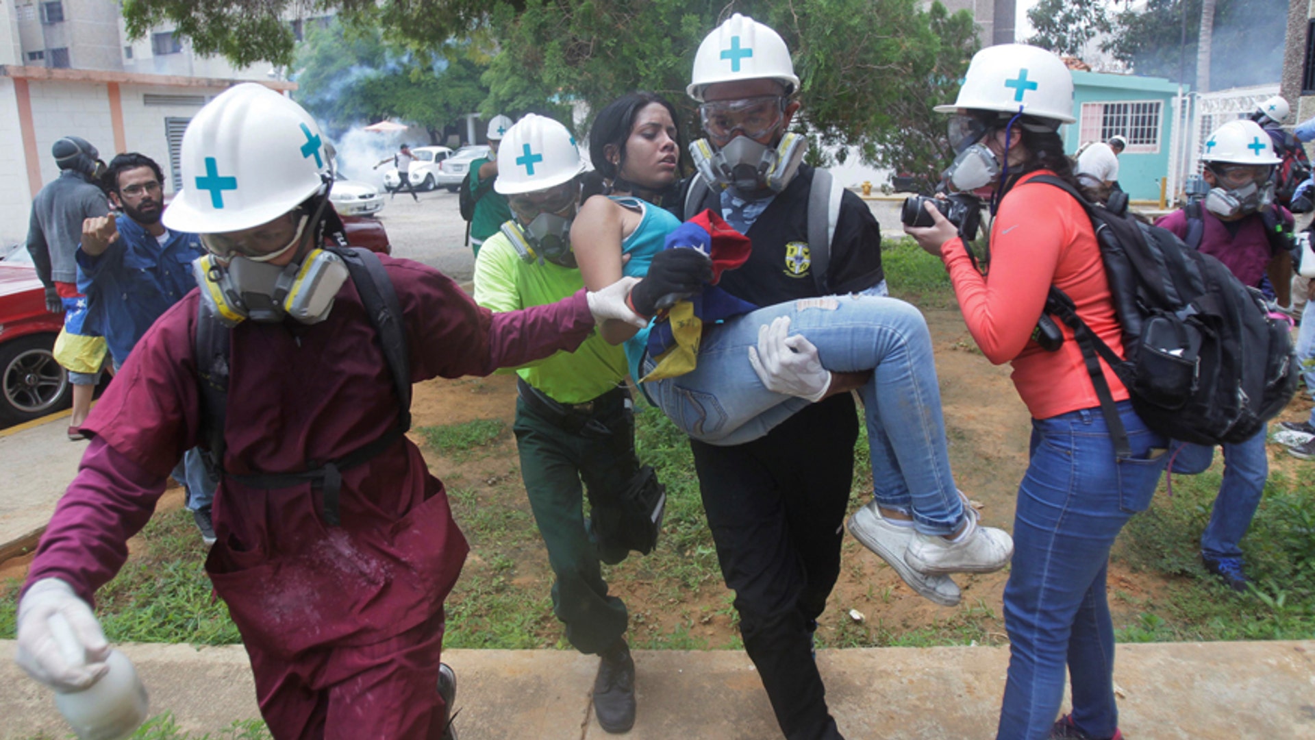 Volunteers, members of a primary care response team, carry an injured opposition supporter during a rally in Maracaibo, Venezuela