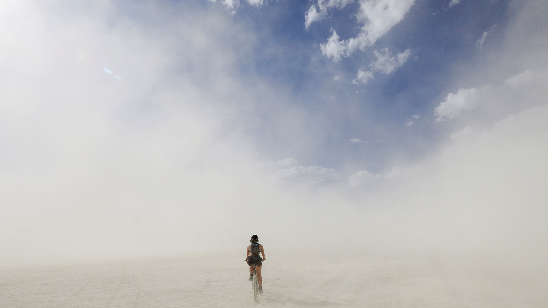 A lone Burning Man participant cycles through a desert dust storm at the annual Burning Man arts and music festival in Nevada, August 30