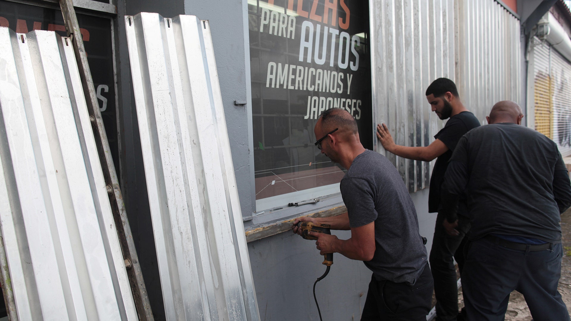 Men cover the windows of a auto parts store in preparation for Hurricane Irma, in San Juan, Puerto Rico 