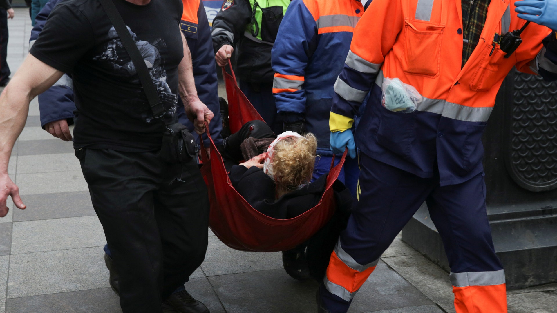 An injured person is helped by emergency services outside Sennaya Ploshchad metro station in Russia.