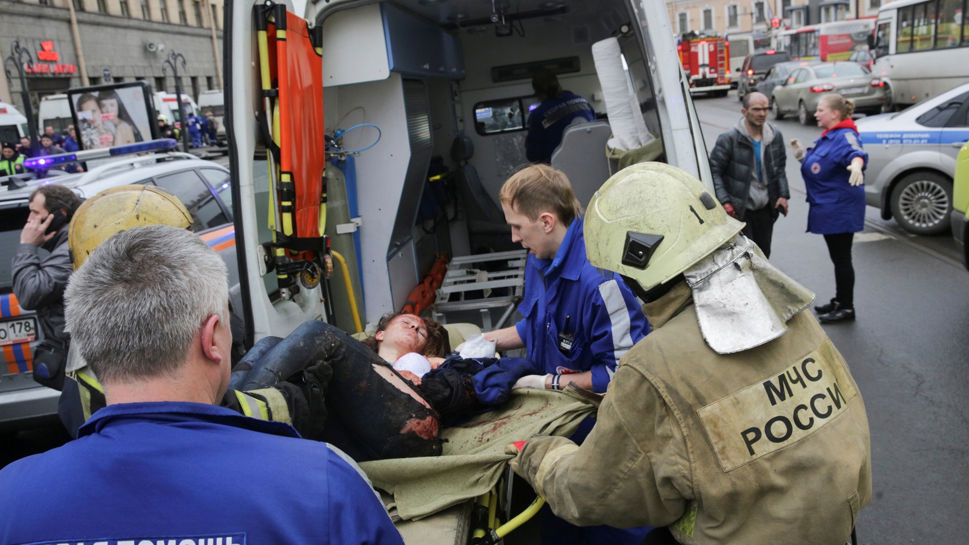 An injured woman is helped by emergency services outside Sennaya Ploshchad metro station