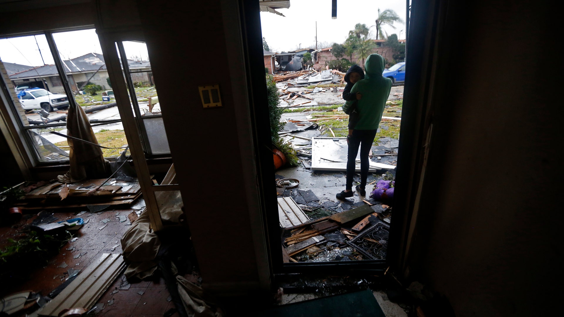 Eshon Trosclair holds her son Camron Chapital after a tornado tore through home while they were inside.