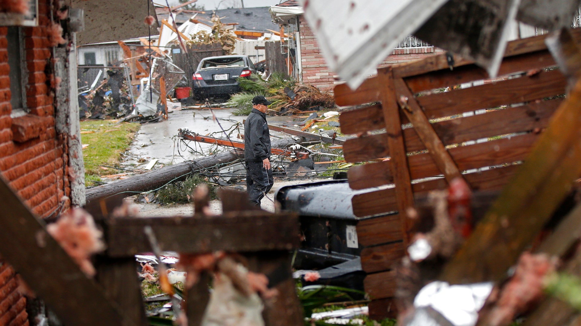 A man walks down the street past destroyed homes after a tornado tore through the eastern part of New Orleans.
