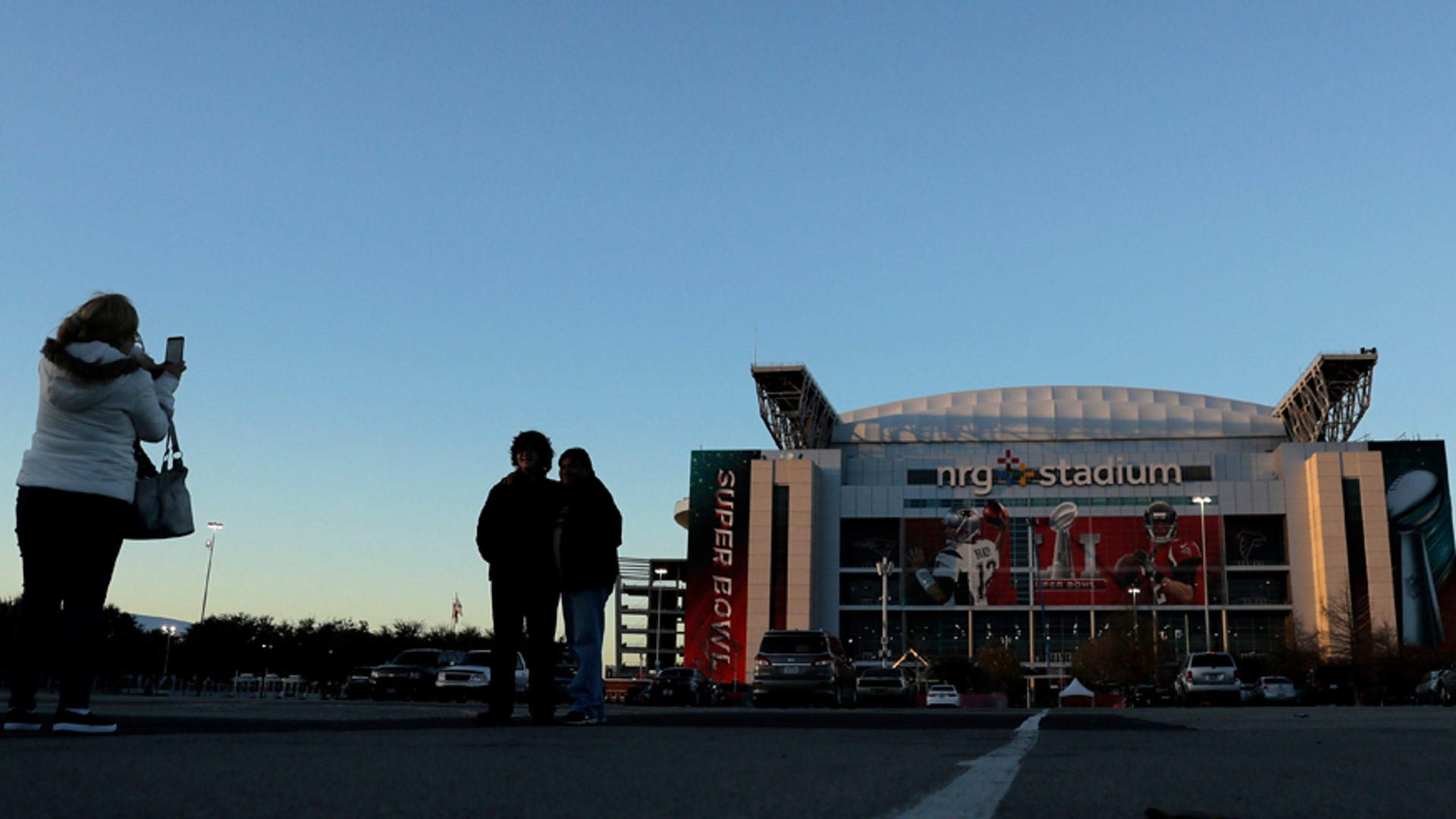People pose for photos in front of NRG Stadium in Houston, Texas.