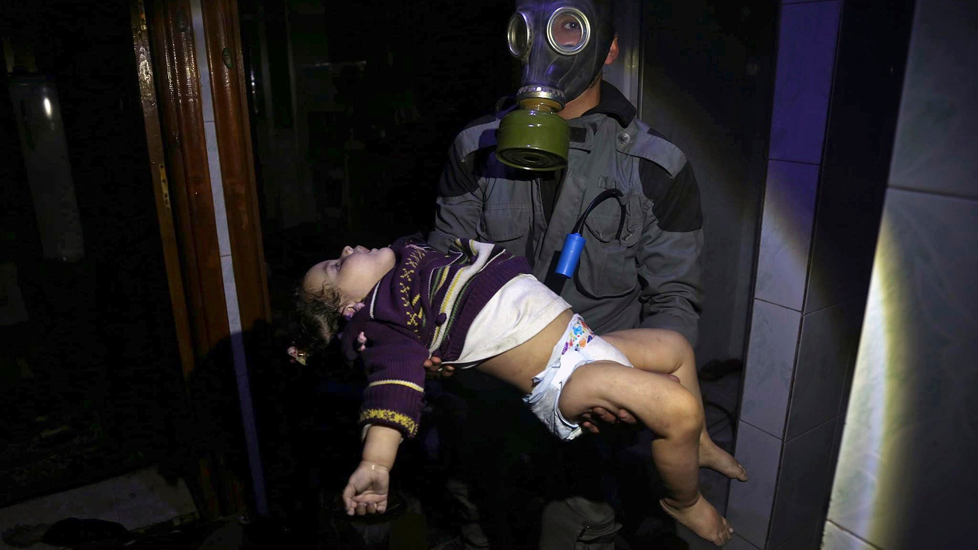 A rescue worker carrying a child following an alleged chemical weapons attack in the rebel-held town of Douma, near Damascus, Syria.