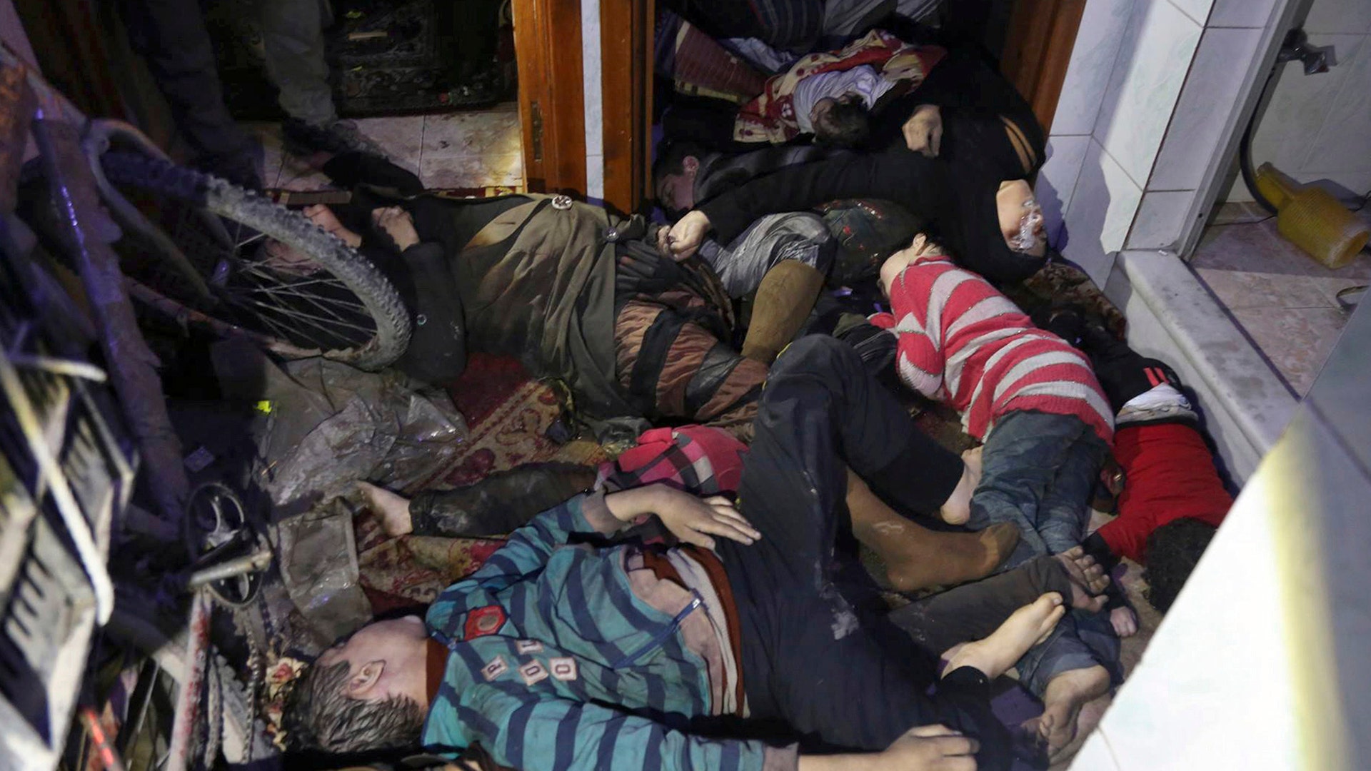 Victims of an alleged chemical weapons attack collapsed on the floor of a building in the rebel-held town of Douma, near Damascus, Syria