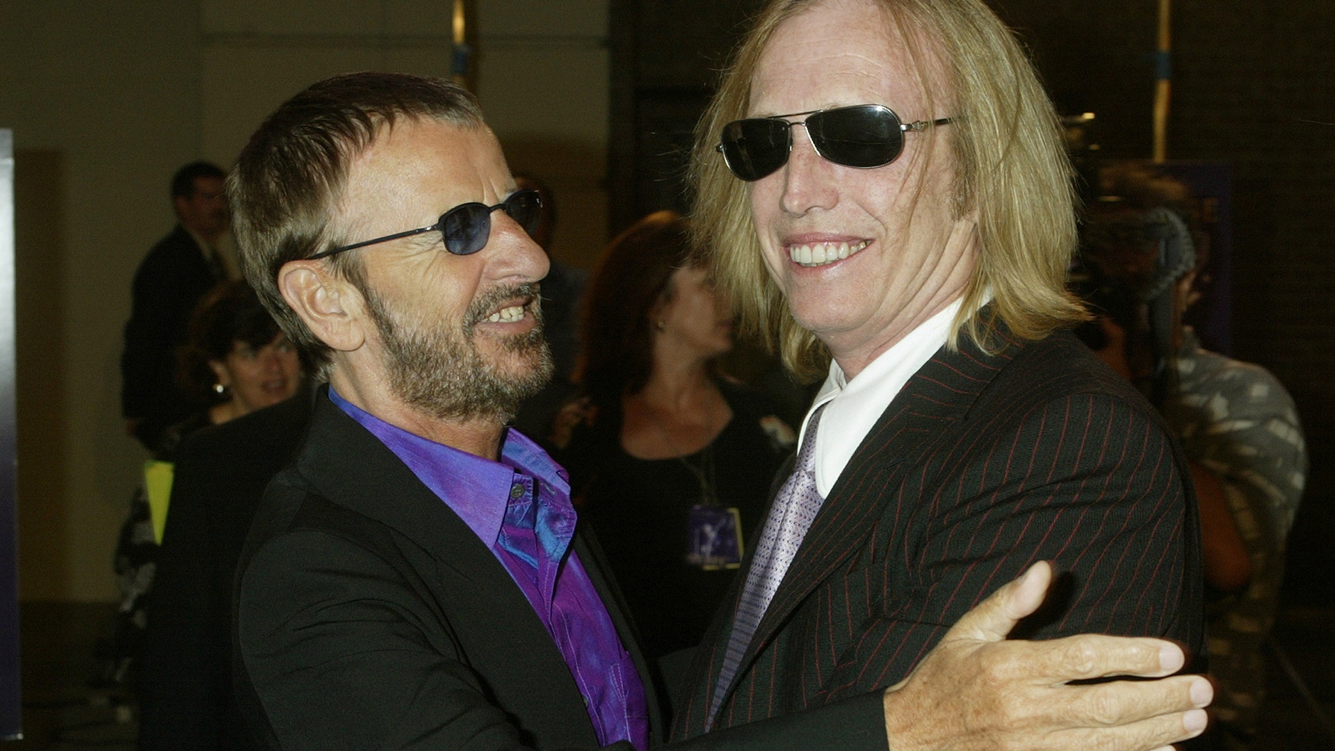 Musician Ringo Starr, greets musician Tom Petty as he arrives for a screening of 