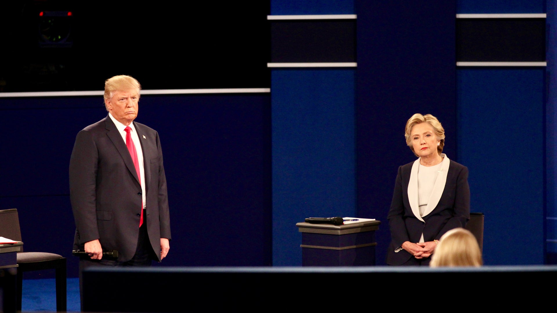 Donald Trump and Hillary Clinton listen to a question.