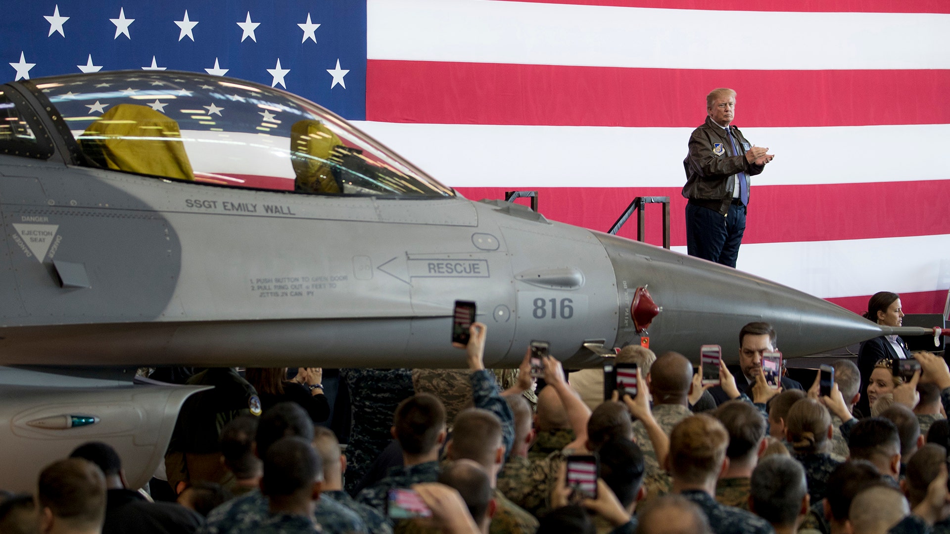 President Trump applauds on stage after speaking at a hangar rally at Yokota Air Base on the outskirts of Tokyo, Japan.