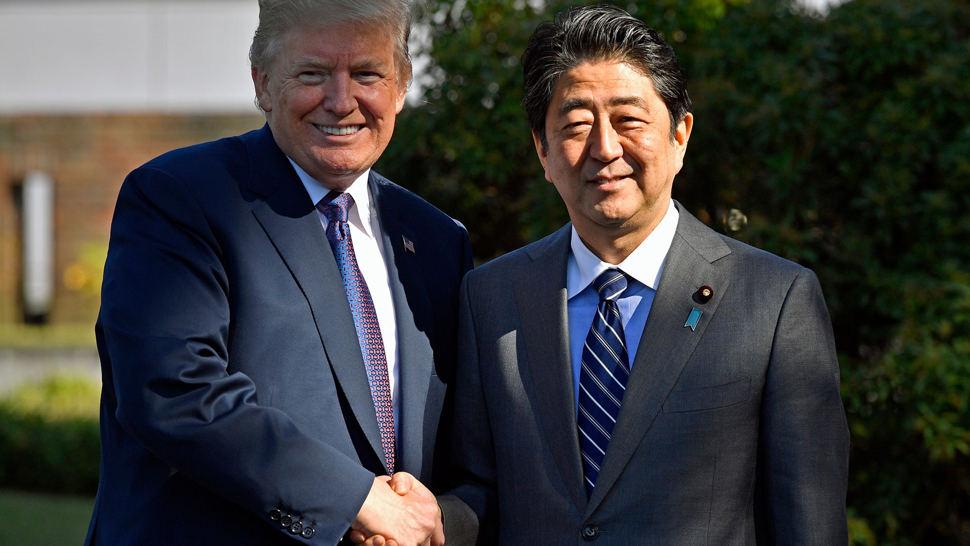 President Trump, shakes hands with Japanese Prime Minister Shinzo Abe at Kasumigaseki Country Club.