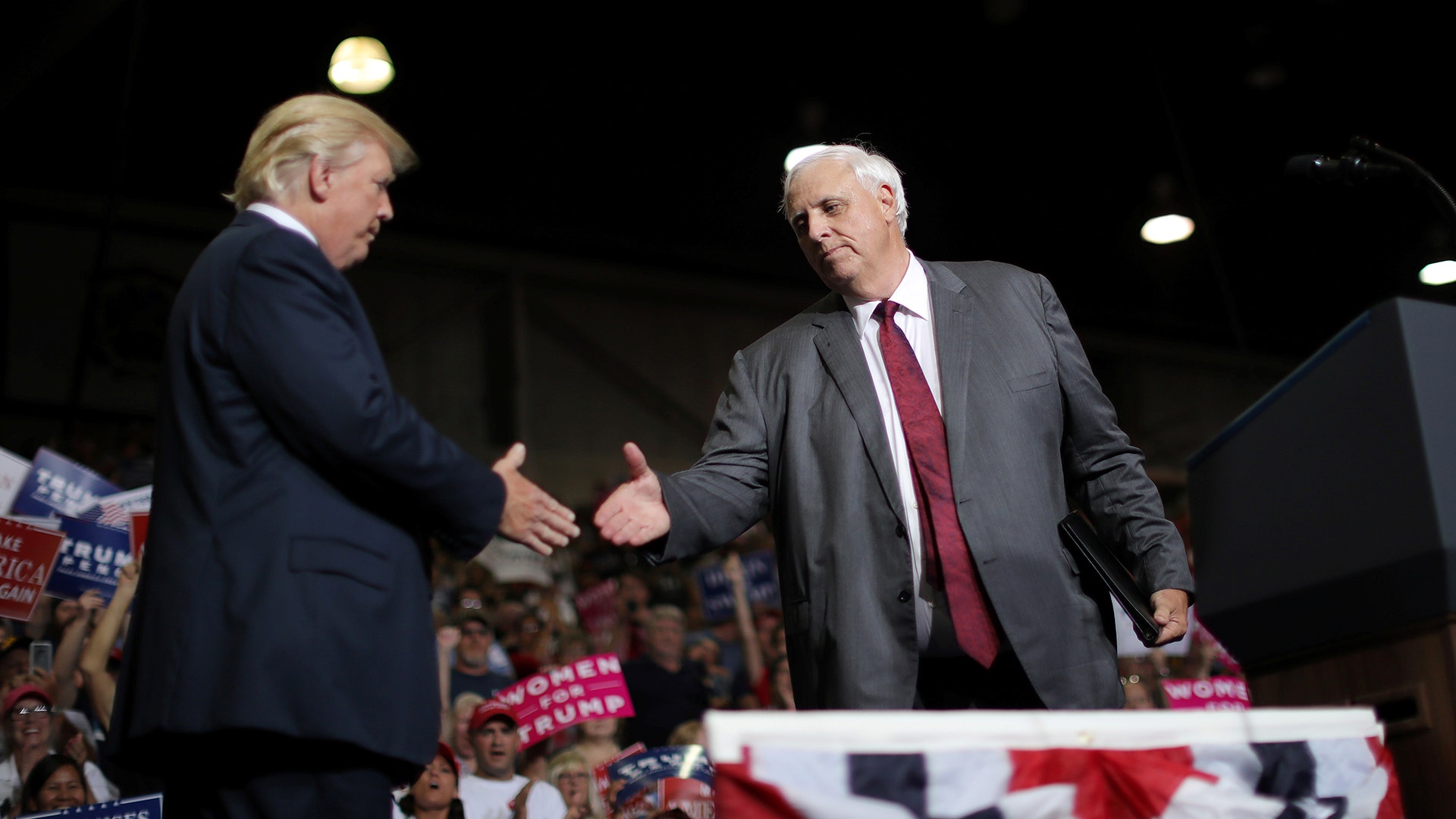U.S. President Donald Trump shakes hands with West Virginia's Democratic Governor Jim in Huntington, West Virginia U.S., August 3.