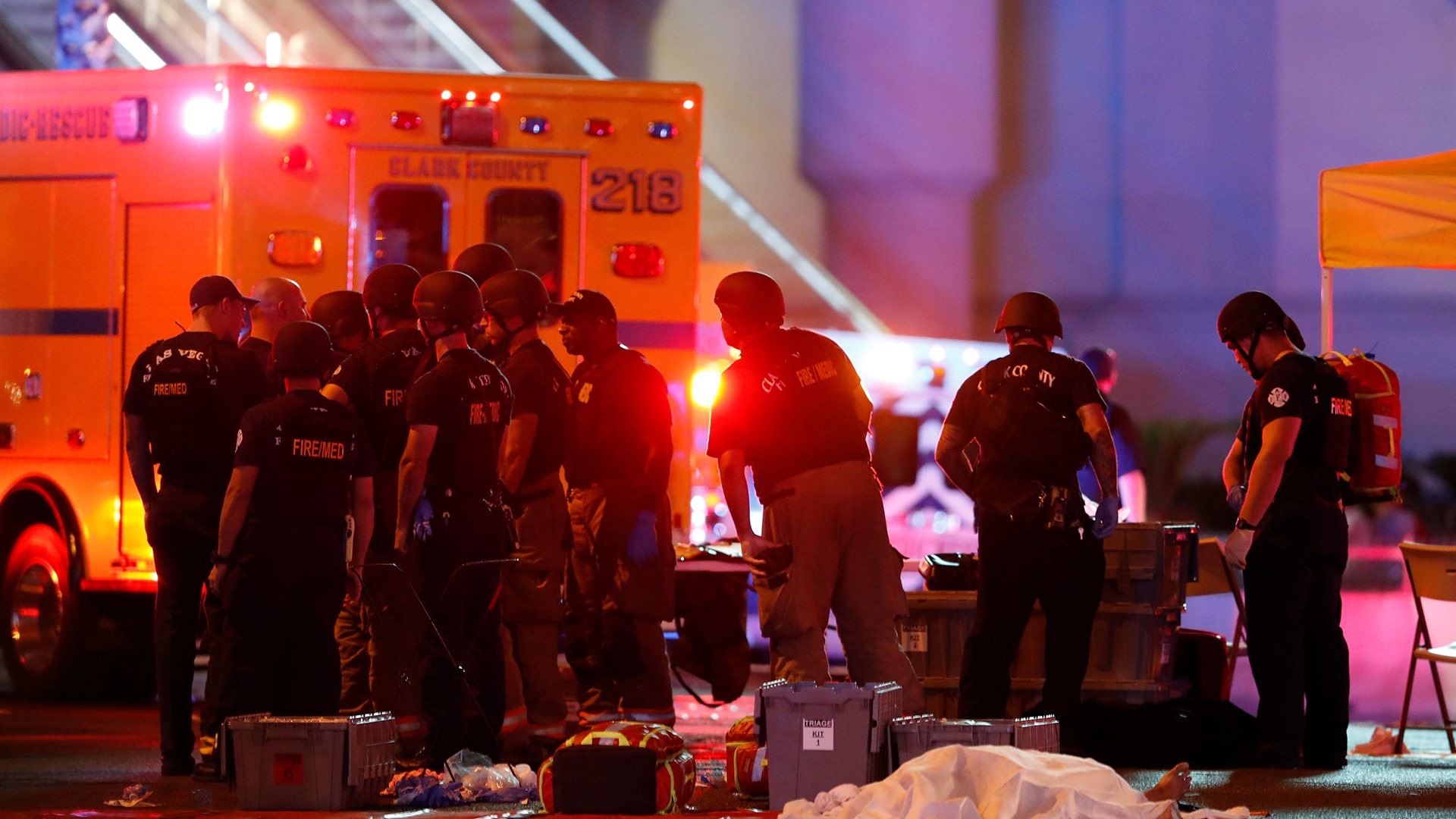A body is covered with a sheet after a mass shooting at a music festival on the Las Vegas Strip, Sunday