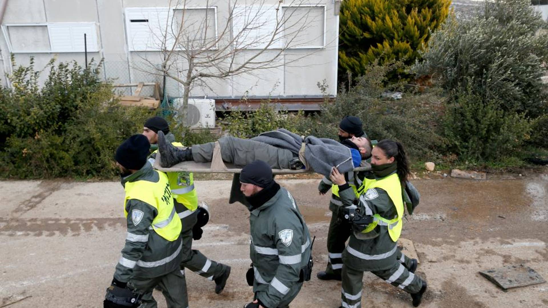 Israeli border police evacuate an injured comrade during an operation by Israeli forces to evict settlers from the illegal outpost of Amona.