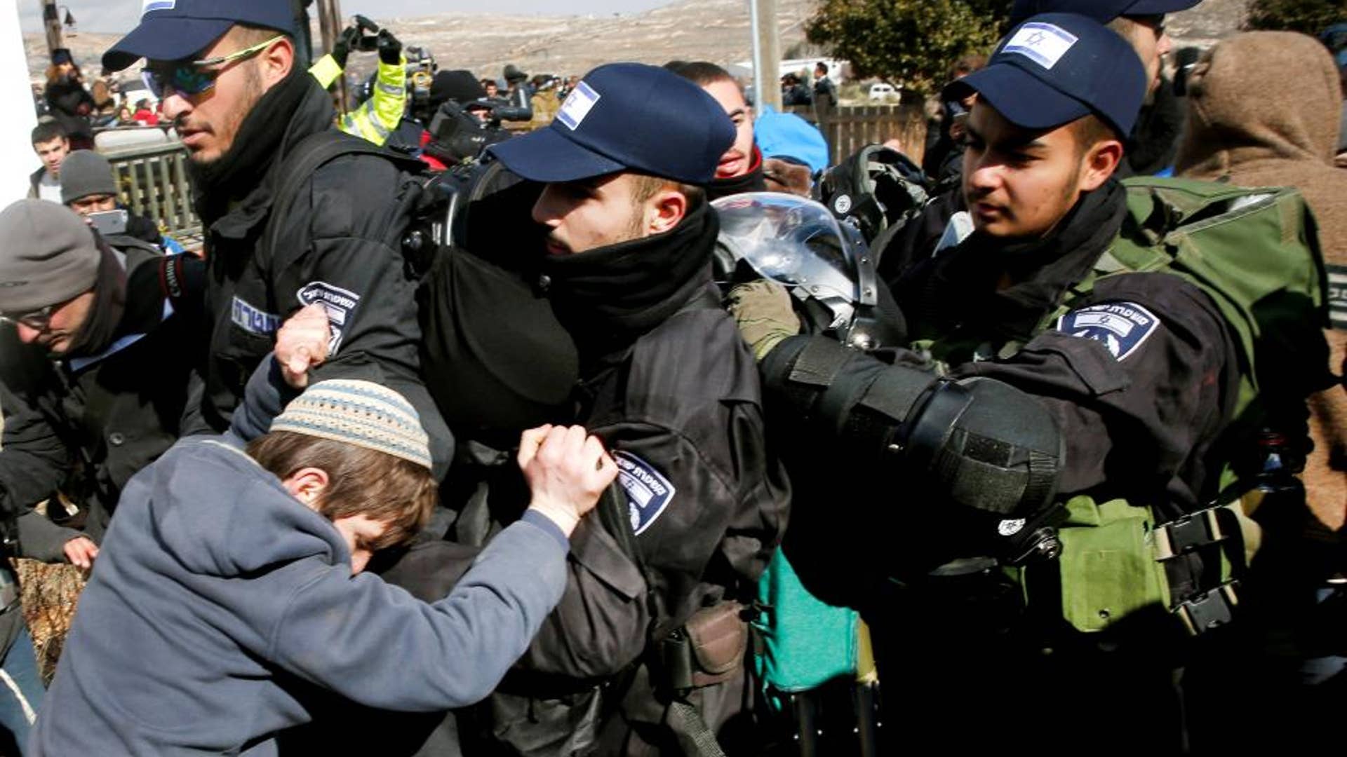 Pro-settlement activists scuffle with Israeli police during an operation by Israeli police to evict residents from Israeli settler outpost of Amona.