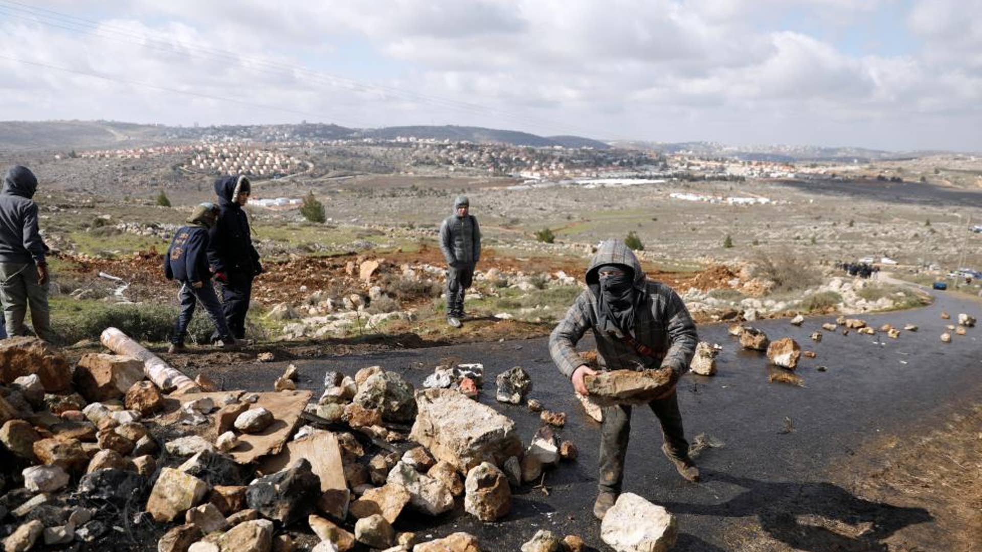 A pro-settlement activists holds a rock during an operation to evict residents from Israeli settler outpost of Amona. 