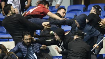 Watch as fans spill onto pitch ahead of Lyon vs. Besiktas to avoid firecrackers in the stands