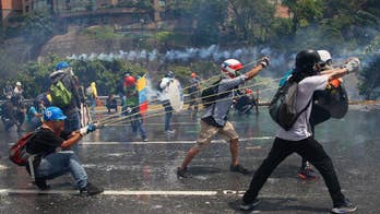 Venezuelans battle with shields, gas masks, fecal bombs