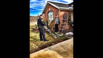 Arkansas police officers help hang Christmas lights on disabled person's home