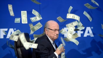 Embattled FIFA president gets doused with dollar bills
