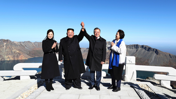 Kim, Moon raise hands on North Korea's sacred volcano