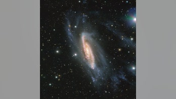 Asteroid hides behind sparkling spiral galaxy in dazzling view