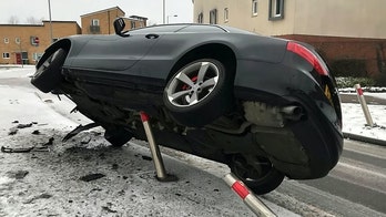 Tipsy driver gets car stuck teetering on pole