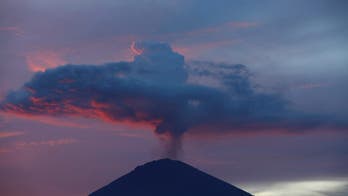 As Bali volcano bubbles, thousands flee while others stay put