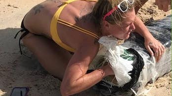 Florida police searching for bikini-clad woman captured hugging bundle of pot on beach