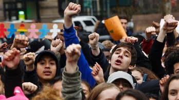 The Latest: Court arguments begin over Trump travel ban