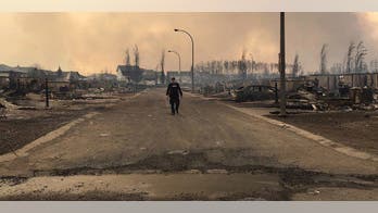 Wildfire evacuees glimpse Canada burned-out city on way out