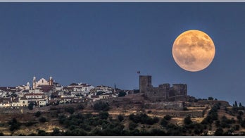 Enormous moon hangs over medieval castle in epic photo