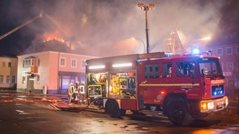 Onlookers cheer as fire damages refugee center in Germany