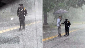 Police officer helps turtle cross road in torrential downpour