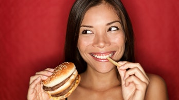 High school student poses with McDonald's food for senior photos