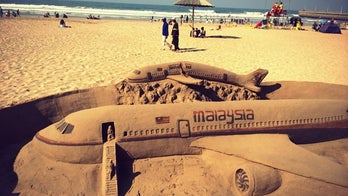 Sand artists sculpt tribute to crashed Malaysian flights