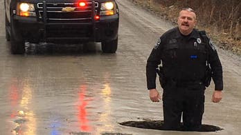 Michigan pothole so large police officer stands knee-deep