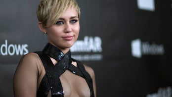 Miley sings duet with topless woman and smokes pot on stage