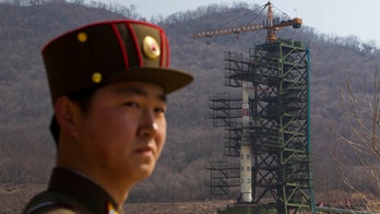 North Korea officials move long-range rocket into position for launch