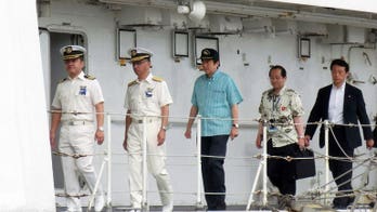 Japan PM Abe visits island near disputed chain