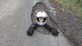 Biker buries skeleton in pothole protest