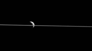 NASA offers up stunning view of Dione divided by Saturn's rings