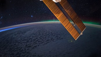 Dazzling auroras dance on the southern horizon in astronaut's photo