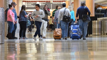 Mystery woman struts through airport wearing only a bikini and mask