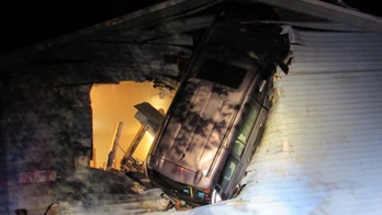 Photos show minivan embedded in side of house after crash